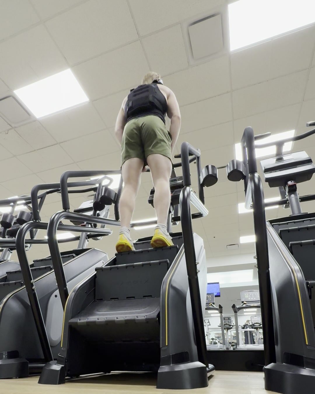 A row of stair steppers in a gym, seen from the floor